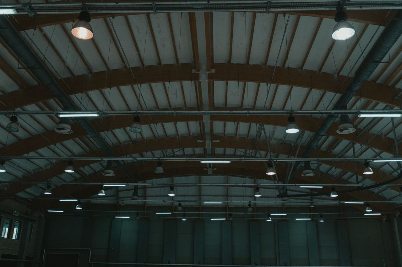 Interior view of an ice skating rink with modern architectural ceiling design.
